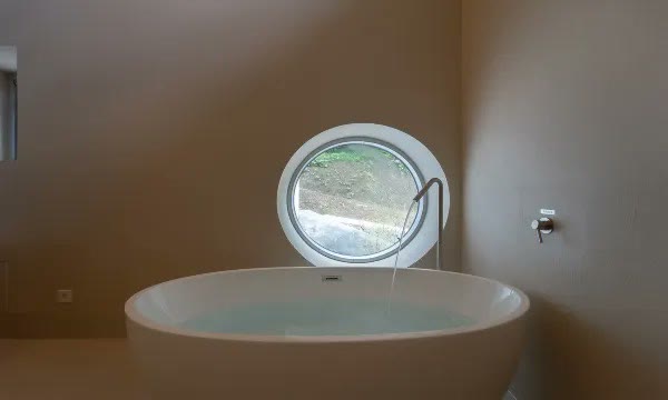 동그란 창 앞에 놓인 거제 화양연화풀빌라 욕조
